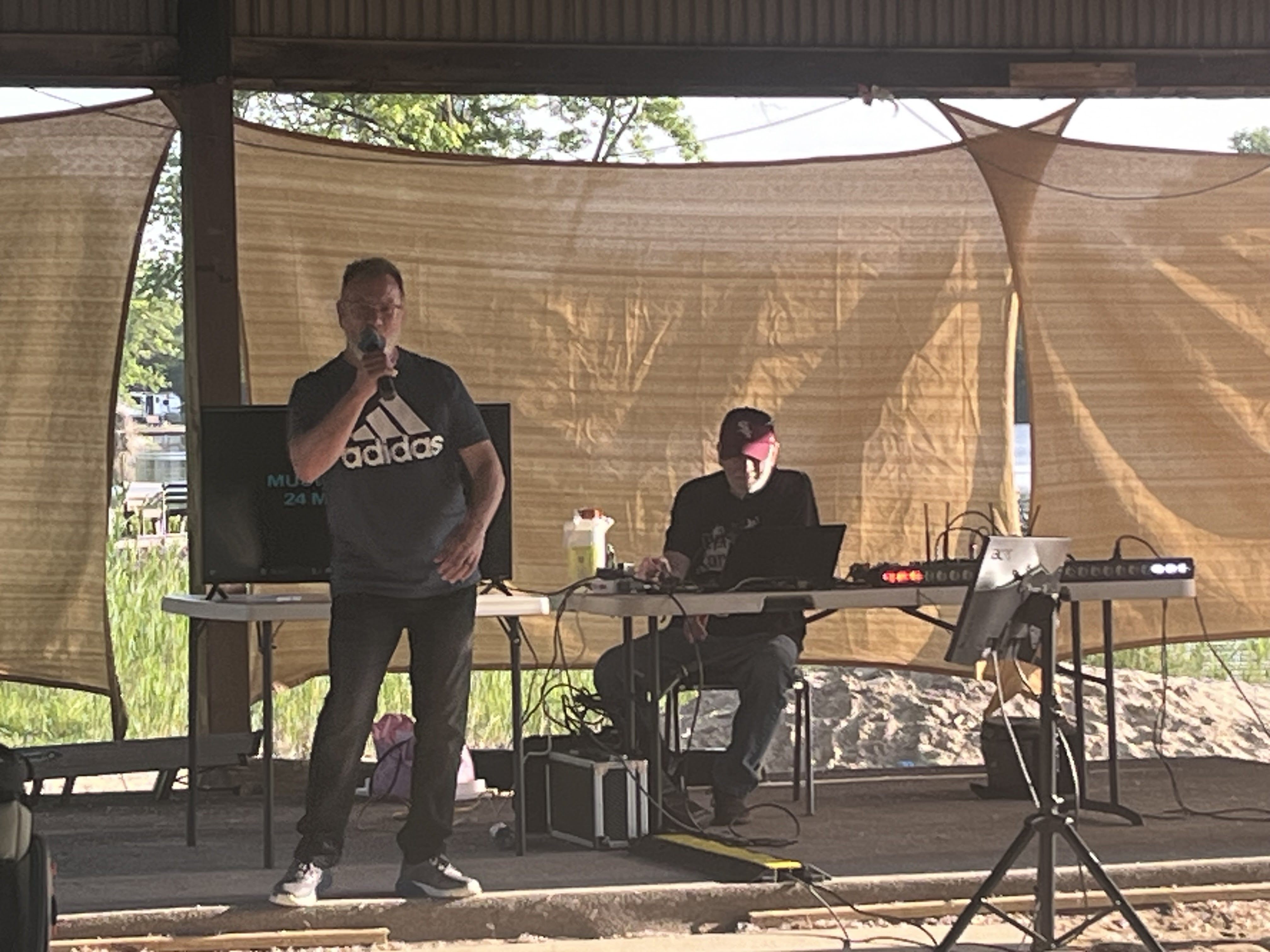 Band performing on stage at the Deer Creek Recreation Club pavilion during a social event