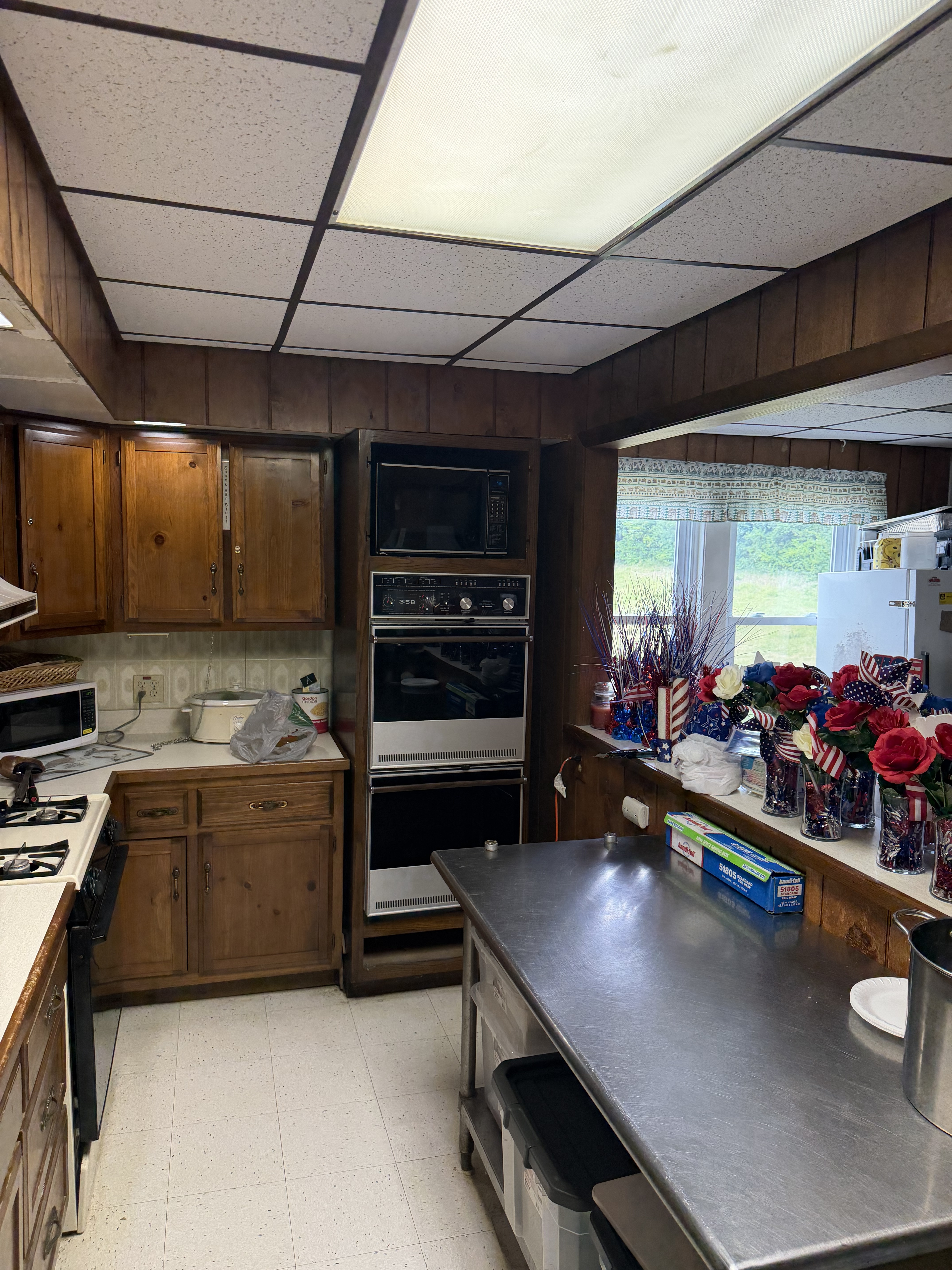 Deer Creek Recreation Club clubhouse kitchen with stainless steel prep island, wall ovens, and full appliances