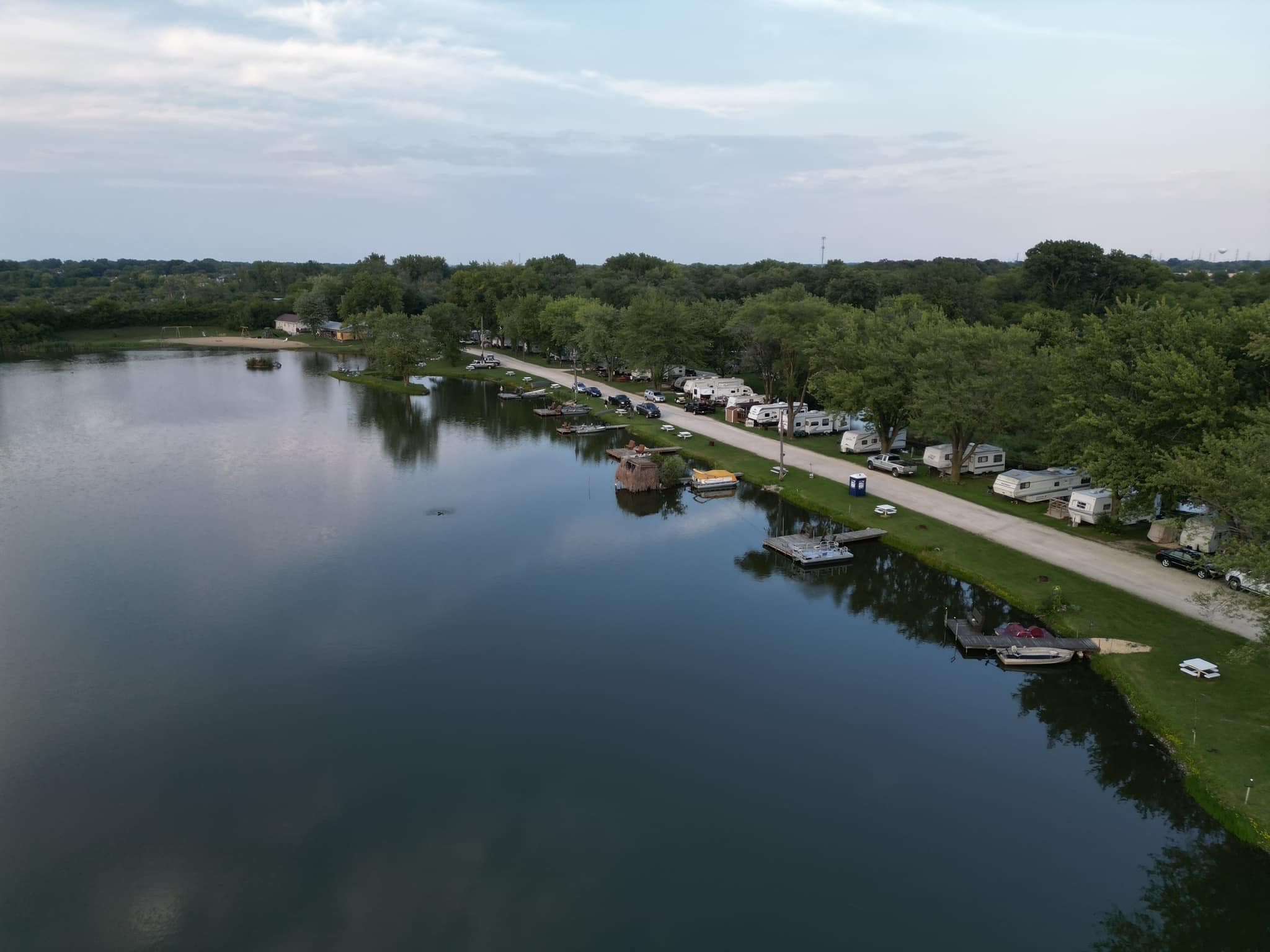 Aerial drone view of Deer Creek Lake with campground, boat docks, and RV sites along the shoreline in Plainfield Illinois