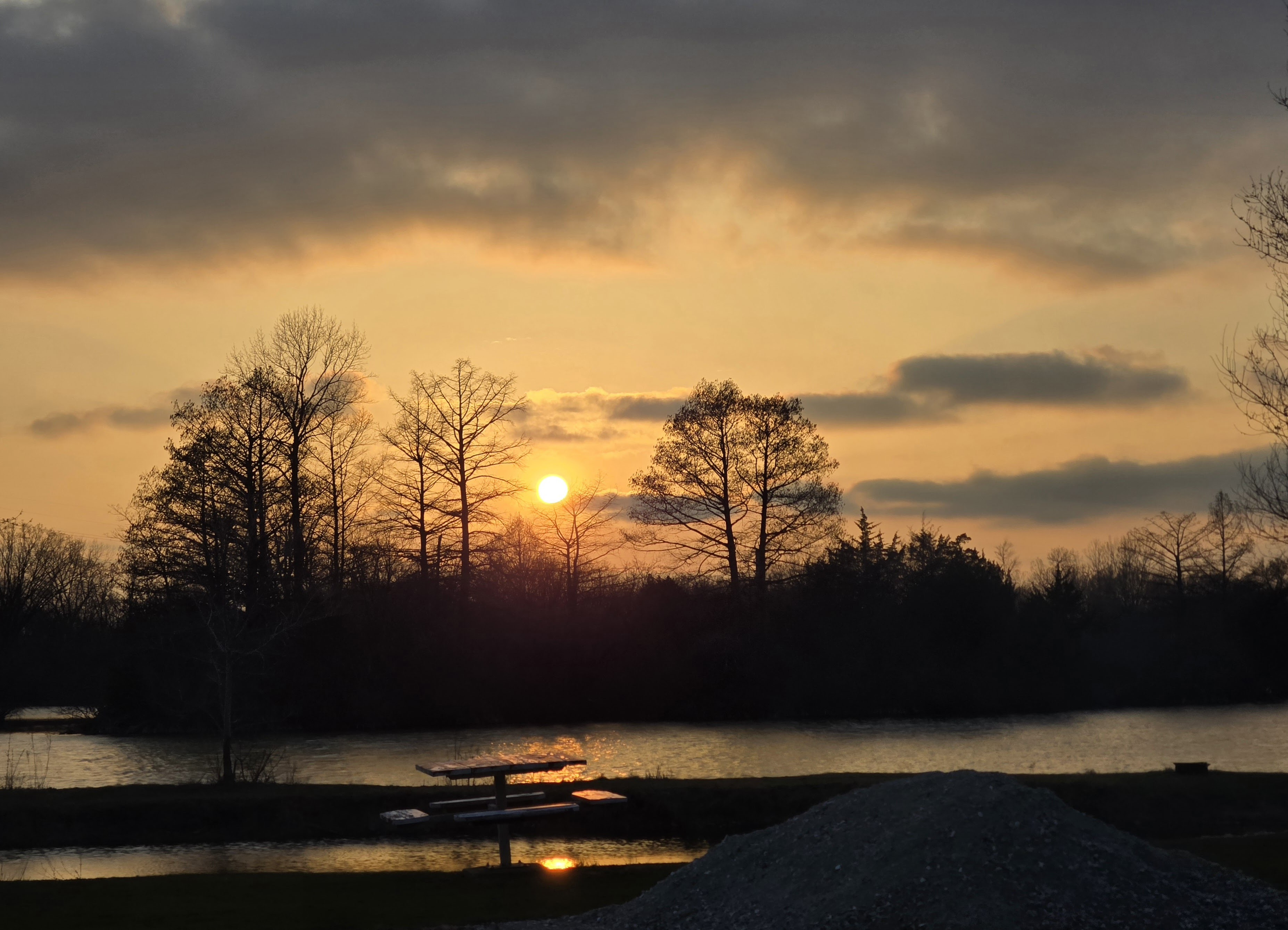 Golden winter sunset over Deer Creek Lake with a dock silhouetted in the foreground in Illinois