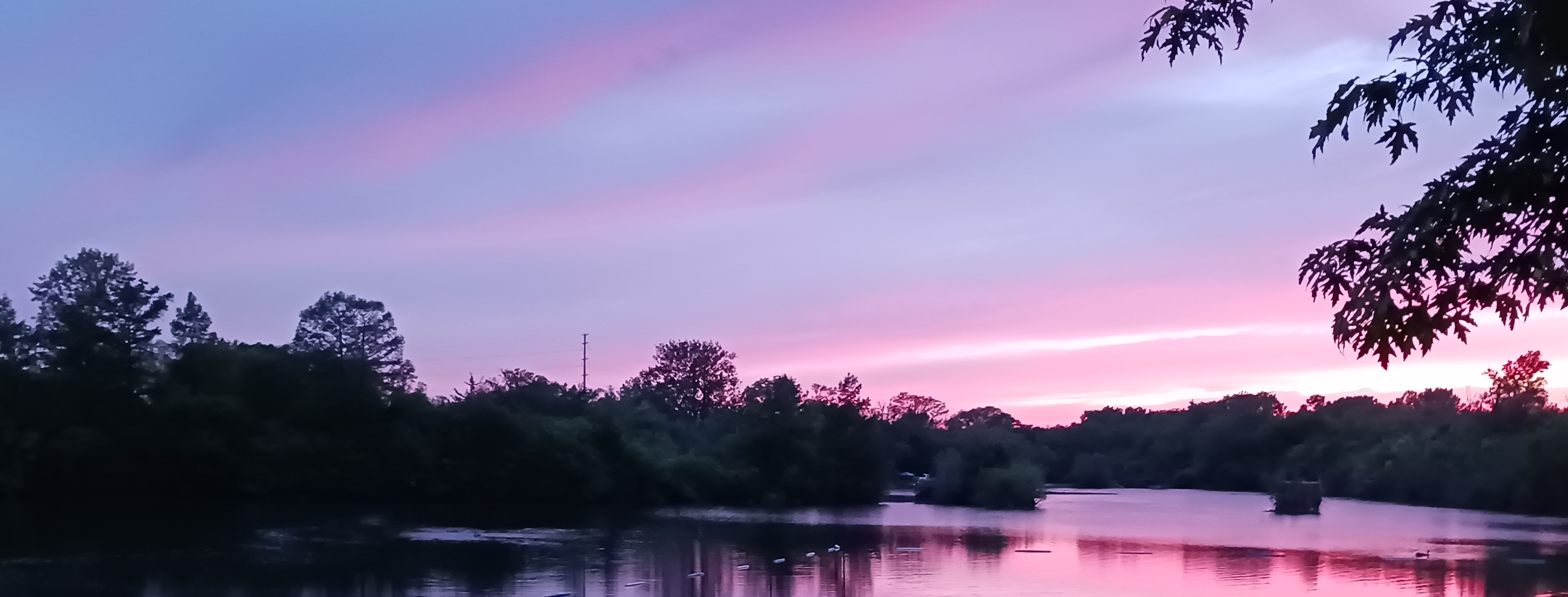 Dramatic purple and pink sunset over Deer Creek Lake at Deer Creek Recreation Club in Plainfield Illinois