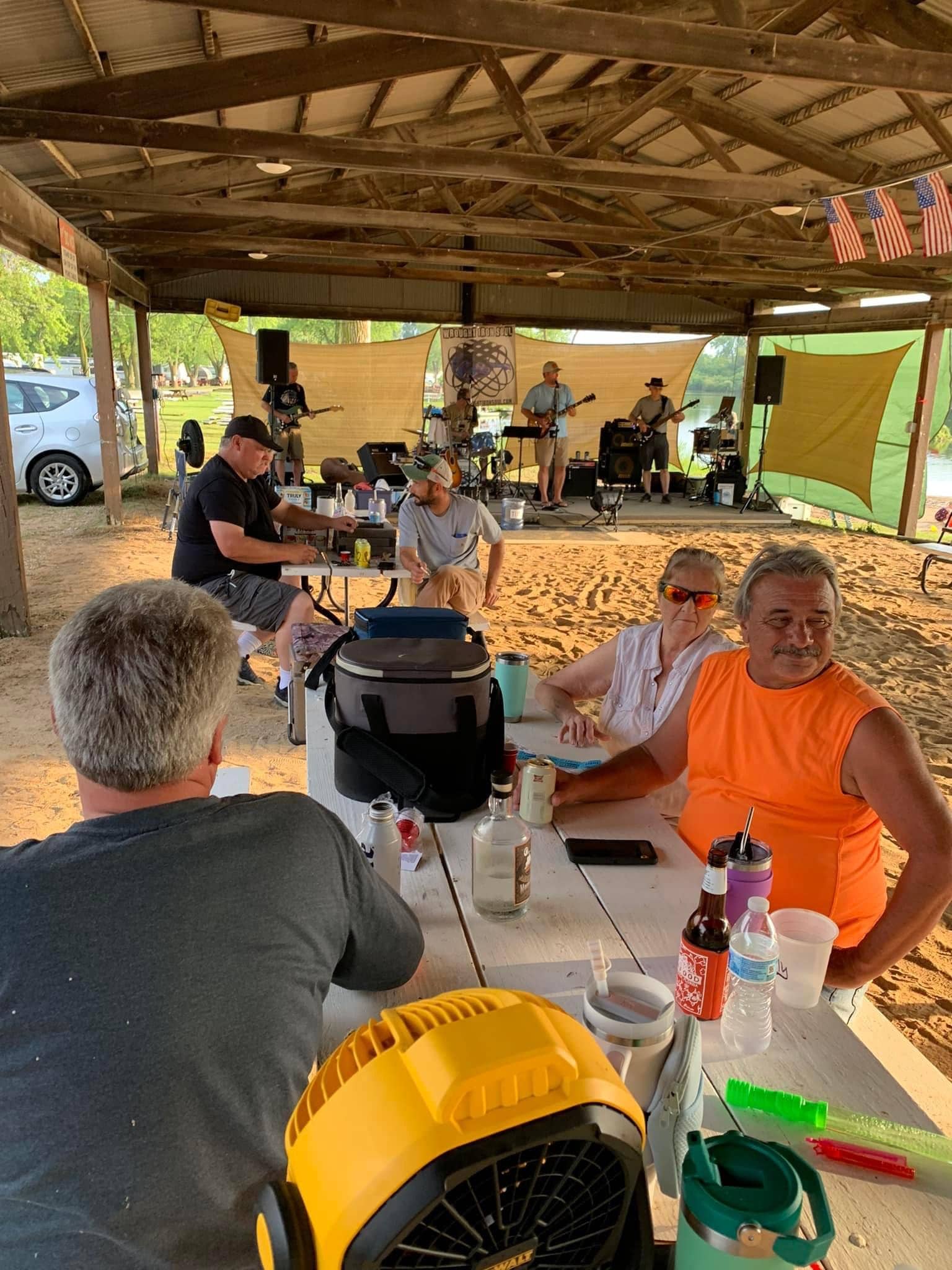Members enjoying a live band performance at the Deer Creek beach pavilion during a summer social event