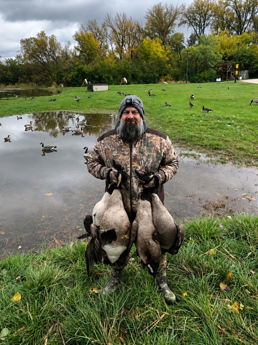 Deer Creek Recreation Club member holding multiple Canada geese after a successful hunt over a decoy spread in Illinois