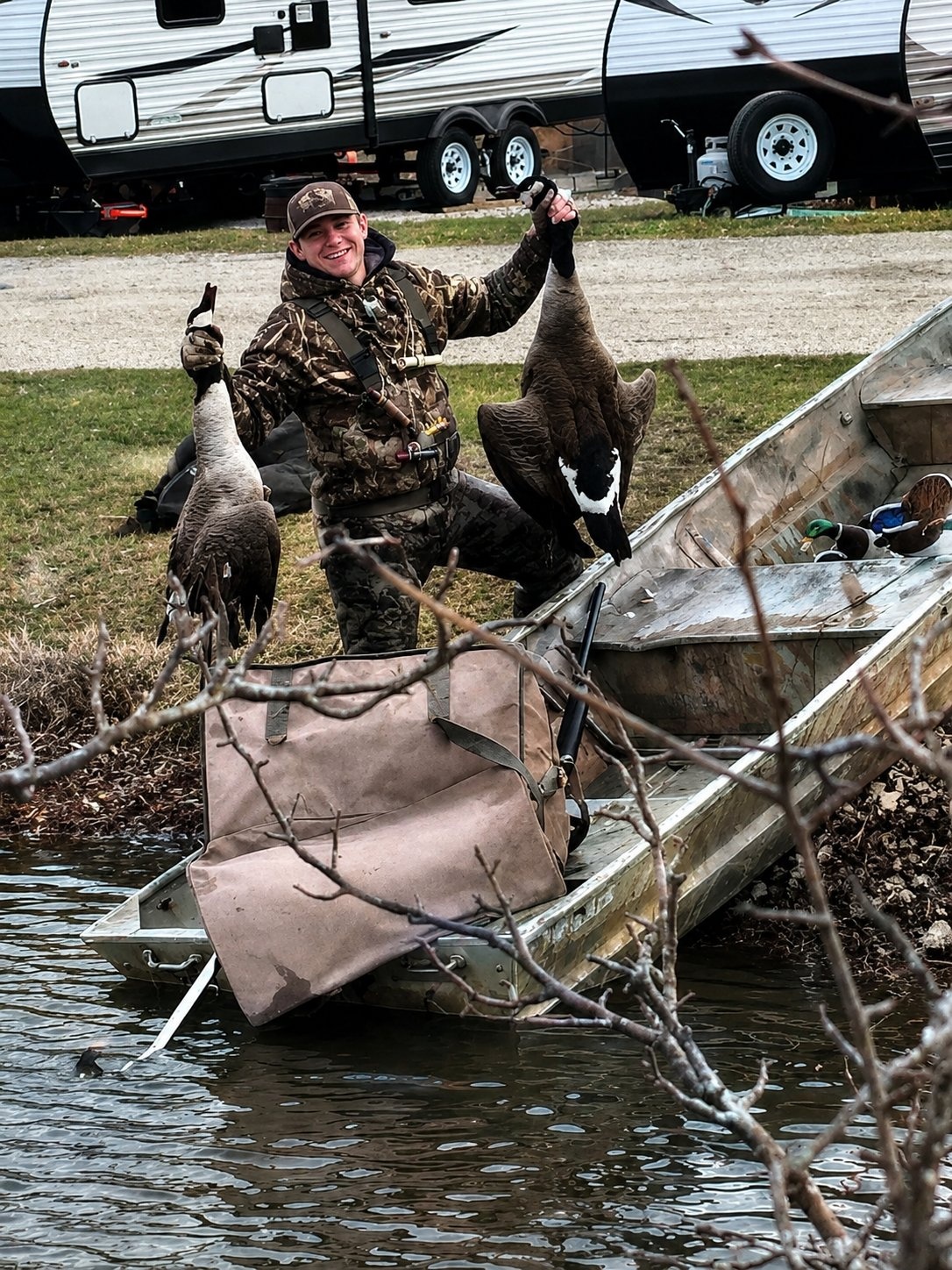 Deer Creek Recreation Club member with harvested Canada geese beside a jon boat at the Deer Creek lake dock