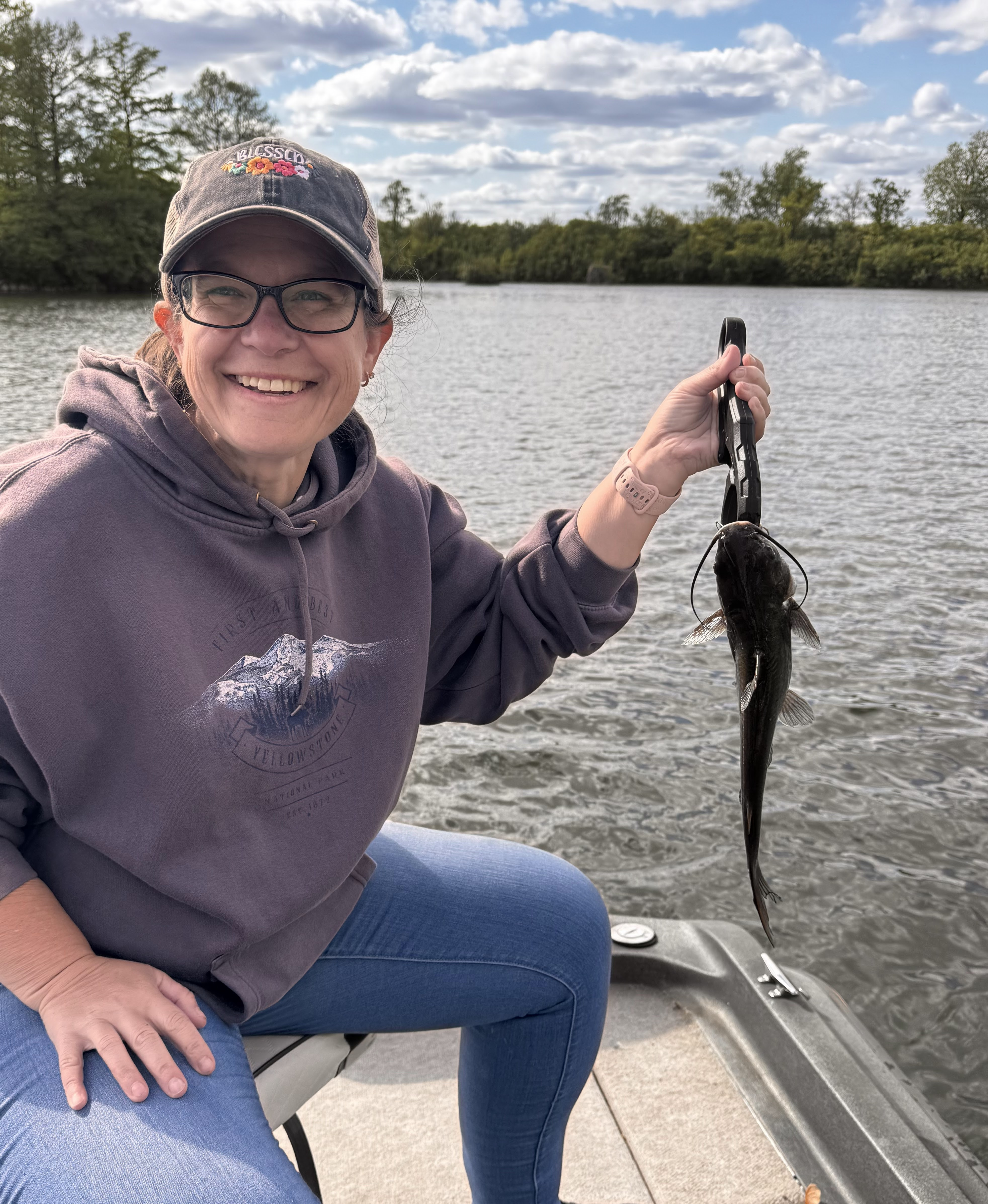 Deer Creek Recreation Club member on a boat holding a catfish caught on the lake