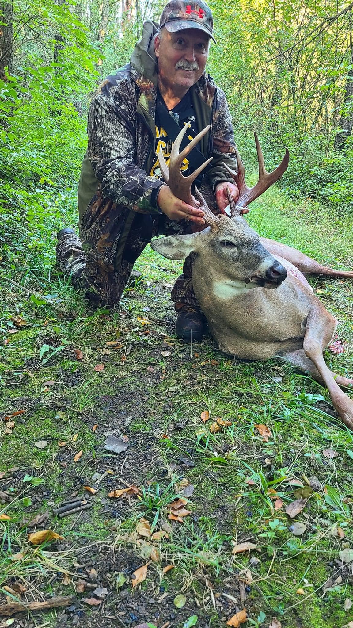 Deer Creek Recreation Club member posing with a harvested trophy whitetail buck in the Illinois woodland