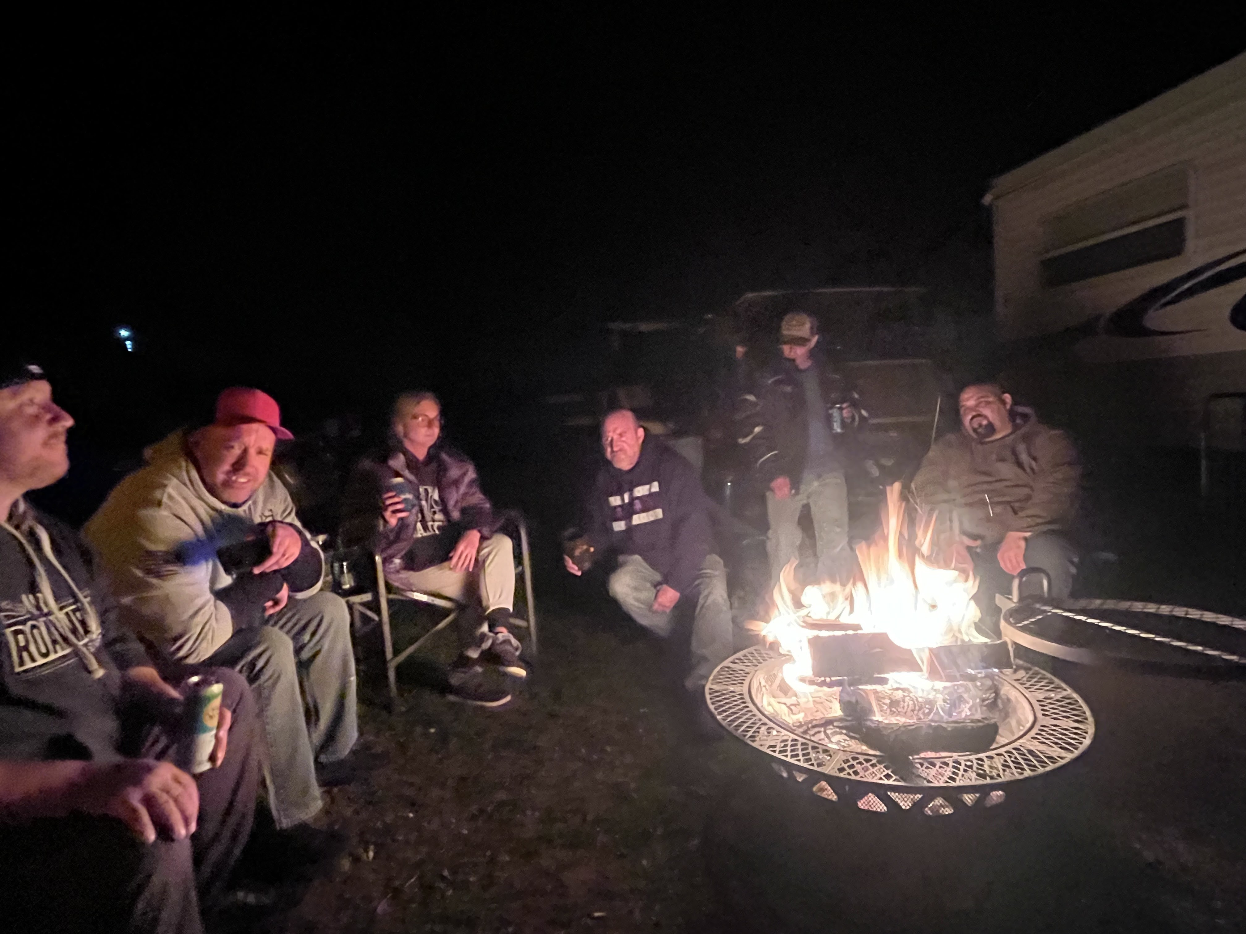 Deer Creek Recreation Club members gathered around a campfire circle at night