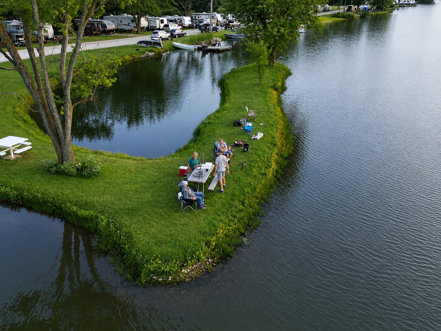 Aerial view of Deer Creek Recreation Club members fishing and relaxing on a grassy peninsula between two lakes