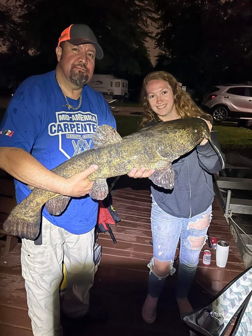 Two Deer Creek Recreation Club members holding an enormous flathead catfish caught during night fishing